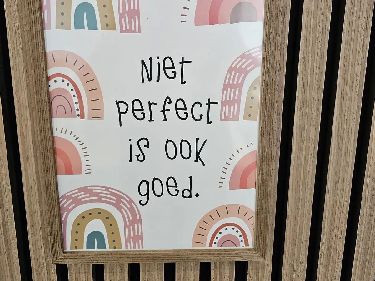 Een poster met regenbogen: „Niet perfect is ook goed.”